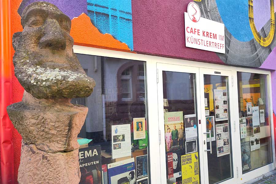 Statue vor Fensterfont des Café Krem